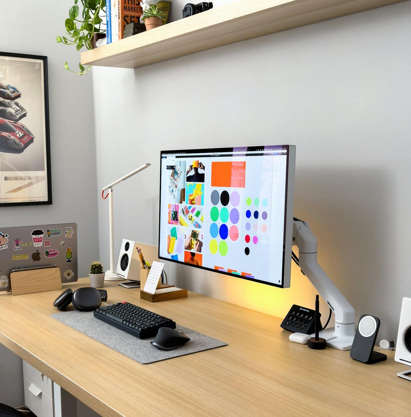 Moderner Schreibtisch im Homeoffice mit Computer, Laptop und Designsoftware.